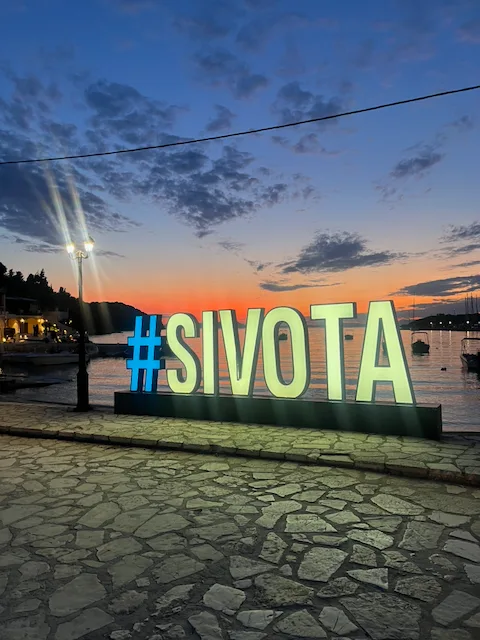 Sivotan kyltti sataman rannassa auringonlaskun jälkeen
